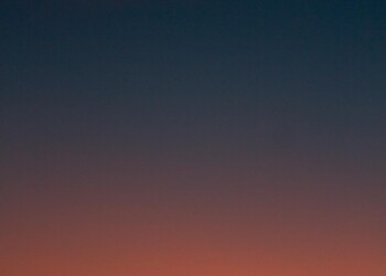 Fiery sunset with crescent moon Crescent moon and fiery orange sunset horizon